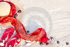 Sand texture with flip flop sandals, hat, pareos, sunglasses.