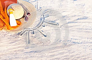 Sand texture with hat, towel, sunscreen and sunglasses. photo