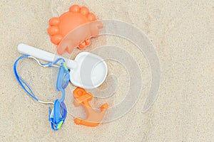 Sand toys next to the diving glasses on the sand.