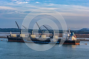 Sand transshipment operations from bulk carrier vessel anchored to mooring buoys to a self-propelled sand carrier barge near the