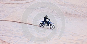 Sand, travel or athlete driving motorcycle for action, adventure or fitness with performance or adrenaline. Desert