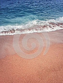 Sand and water texture. Soft sea foam wave on the golden sandy beach. Summer holiday refreshment background