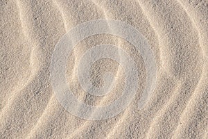 Sand, wave, reflect, shadow, light, beige. Patterns in a sand of dune like ruffle in water. Close-up.