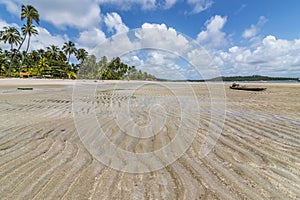 Sand wave-shaped and old raft in a tropical beach