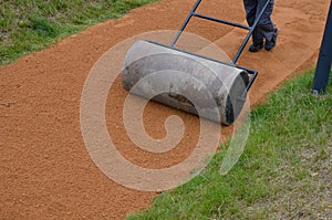 Sand wheeling. garden wheelbarrow carries a worker and pours on piles of beige gravel to repair park, forest, dirt road. erosion c