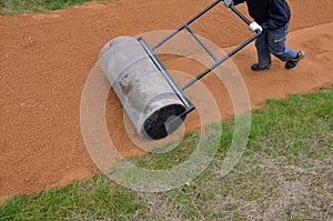 Sand wheeling. garden wheelbarrow carries a worker and pours on piles of beige gravel to repair park, forest, dirt road. erosion c