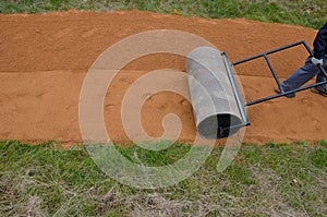 Sand wheeling. garden wheelbarrow carries a worker and pours on piles of beige gravel to repair park, forest, dirt road. erosion c