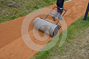 Sand wheeling. garden wheelbarrow carries a worker and pours on piles of beige gravel to repair park, forest, dirt road. erosion c