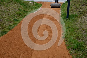 Sand wheeling. garden wheelbarrow carries a worker and pours on piles of beige gravel to repair park, forest, dirt road. erosion c