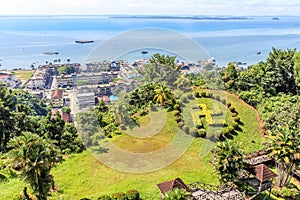 Sandakan town landscape with green lawn in Hindu counterclockwise swastika shape and blue Sulu sea in