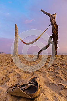 Sandals on beach with hammock