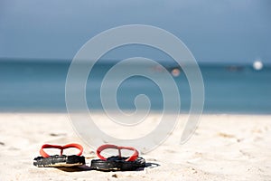 The sandals places on white-yellow sand beach