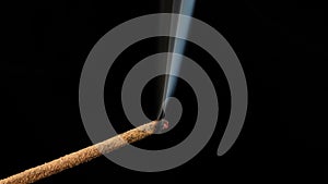 Sandalwood stick with incense smokes on a black background