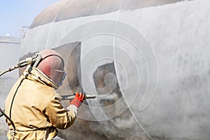 Sandblasting or abrasive blasting with grit. Sandblasting is used for cleaning industrial as well as commercial structures. photo