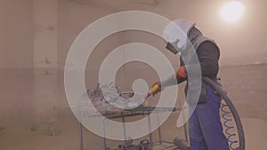 Sandblasting metal parts in a factory. Sandblasting the part. Sandblasting