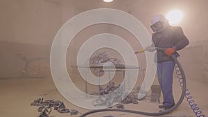 Sandblasting. Sandblasting the part. Sandblasting metal parts in a factory.