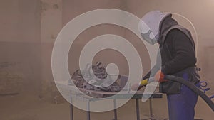 Sandblasting. Sandblasting the part. Sandblasting metal parts in a factory.
