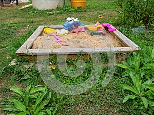 Sandbox with plastic toys in the village