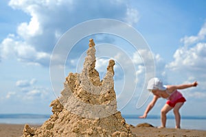 Sandcastle and playing child
