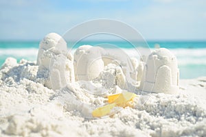 Sandcastle and shovel on Florida beach with white sand