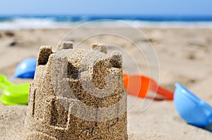 Sandcastle and toy shovels on the sand of a beach