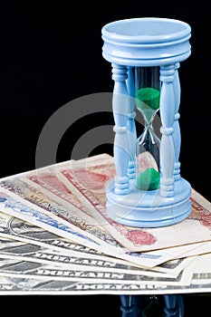 Sandclock on bank note represent money grow over time