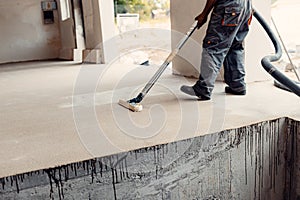 The sanded concrete screed is vacuumed with an industrial vacuum cleaner