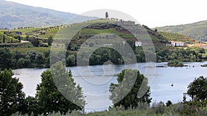 Sandeman silhouette on a hill over vineyards, across Douro River, Peso da Regua, Portugal