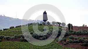 Sandeman silhouette on a hill over vineyards, across Douro River, Peso da Regua, Portugal