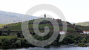 Sandeman silhouette on a hill over vineyards, across Douro River, Peso da Regua, Portugal
