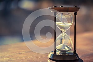 A sandglass, modern hourglass or egg timer with shadow showing the last second or last minute or time out.