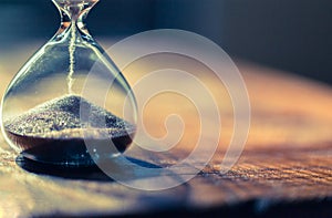 A sandglass, modern hourglass or egg timer with shadow showing the last second or last minute or time out.