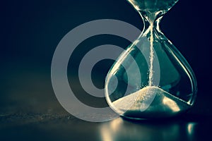 A sandglass, modern hourglass or egg timer with shadow showing the last second or last minute or time out.