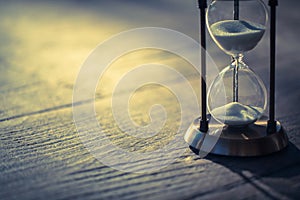 A sandglass, modern hourglass or egg timer with shadow showing the last second or last minute or time out.