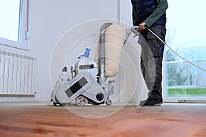 Sanding hardwood floor with the grinding machine photo