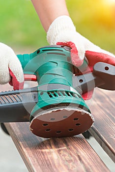 Sanding a wood with orbital sander