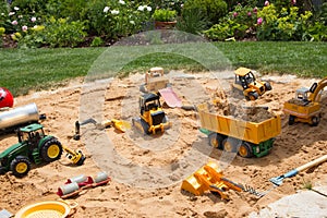 Sandpit in a garden with different sand play things.