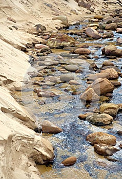 Sandstone boulders in a sandy freshwater creek