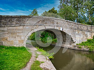 Sandstone Bridge 23 on a quiet, rural section of the Leeds to Liverpool Canal in Lancashire, UK.