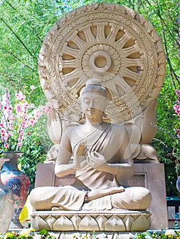 Sandstone Buddha image sitting front Dharmacakra