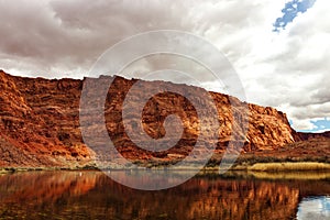 Sandstone mountain reflected on the slow flowing Colorado river, Lees Ferry landing, Page, AZ, USA