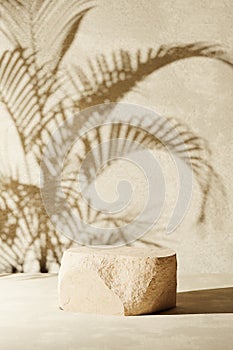Sandstone podium for luxury product placement with palm leaf shadow in background. Natural stone material scene. Minimal luxury
