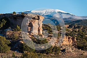 Red rock formation with a snow-capped mountain peak near Santa Fe, New Mexico