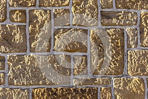 Sandstone wall, bricked with different sized sharpened rustic stone and white joints