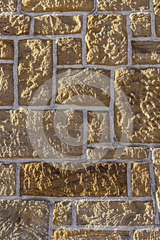 Sandstone wall, bricked with different sized sharpened rustic stone and white joints