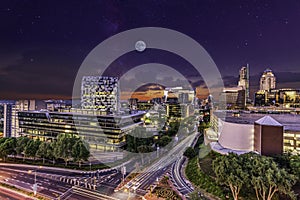 Sandton City skyline lit up at night with moon and stars in the sky