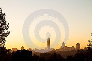 Sandton skyline at sunrise with trees silhouette