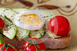 Sandwich with avocado, boiled egg and cherry tomatoes