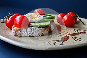 Sandwich with avocado, boiled egg and cherry tomatoes