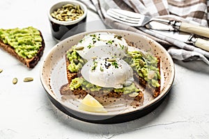 Sandwich with avocado and poached egg. Healthy food concept. Food recipe background. Close up